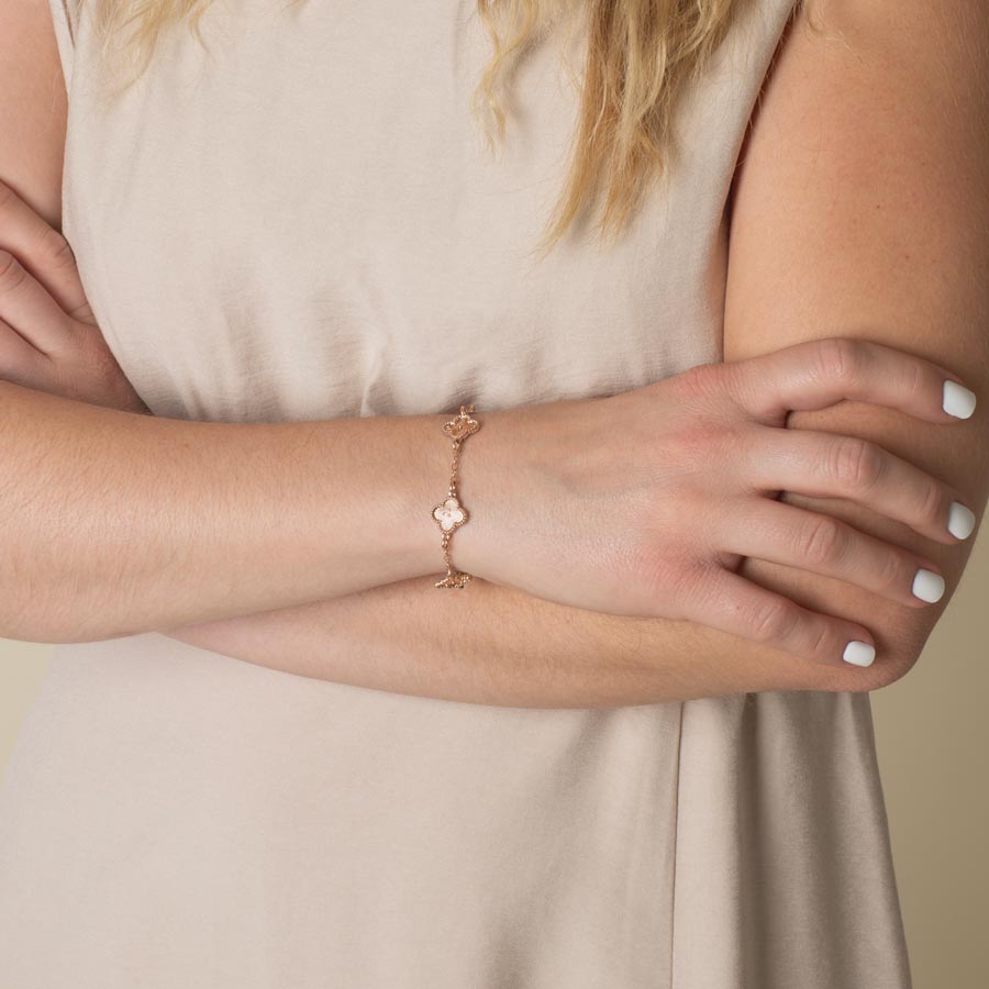 Woman wearing 14k rose gold plated clover shaped medical ID bracelet with starburst textured inlay.