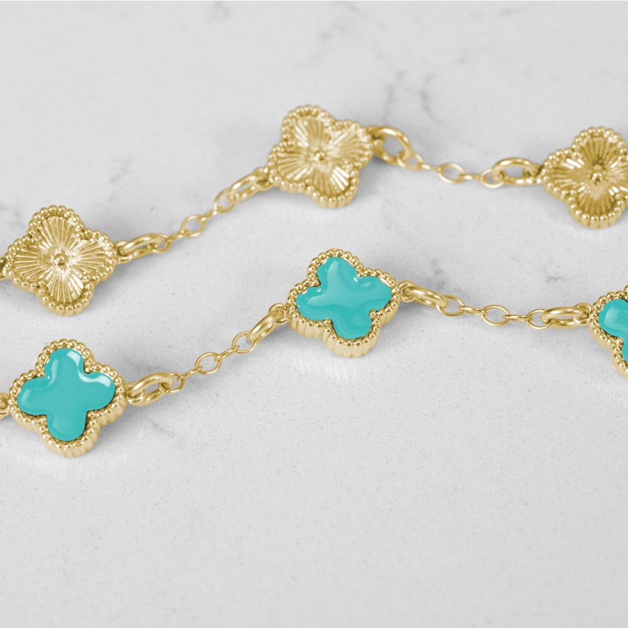 Clover shaped links, inlaid with turquoise paint on the front of each link. The back of each link features a starburst pattern in gold.