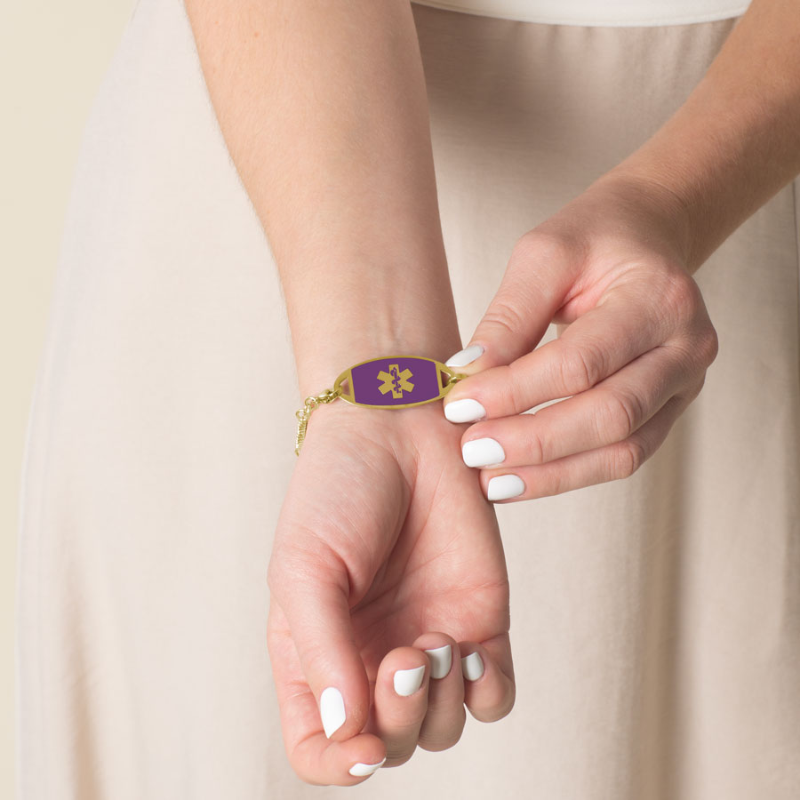 Woman wearing gold tone stainless steel lilac abalone medical ID tag.