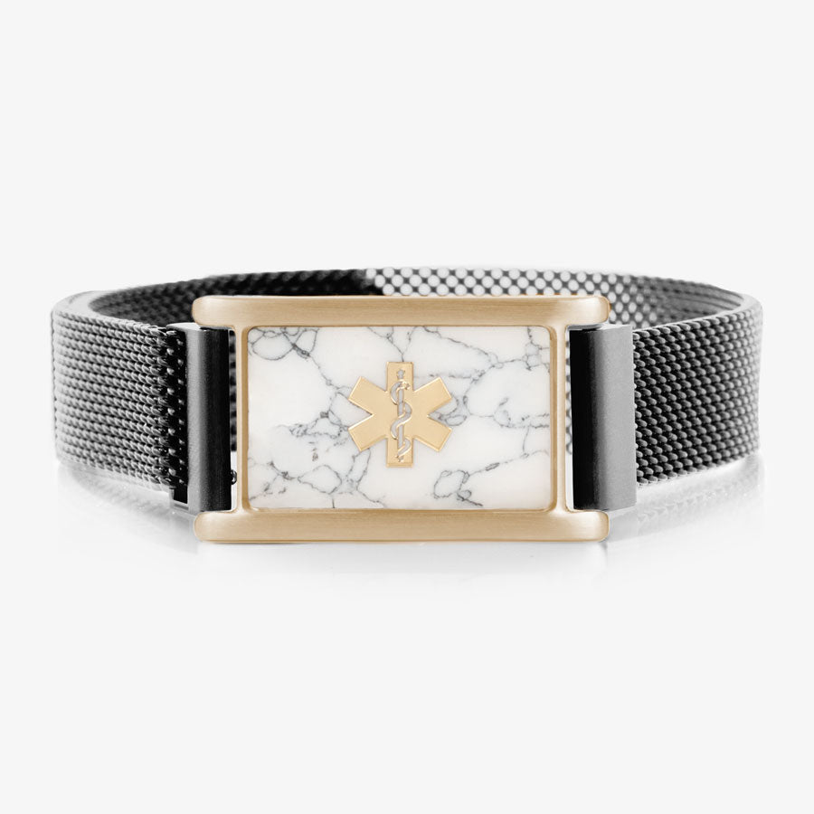 Black stainless steel, adjustable mesh band with magnetic clasp affixed to sandstone stainless steel medical ID tag with howlite inlay and coordinating gold tone medical symbol.