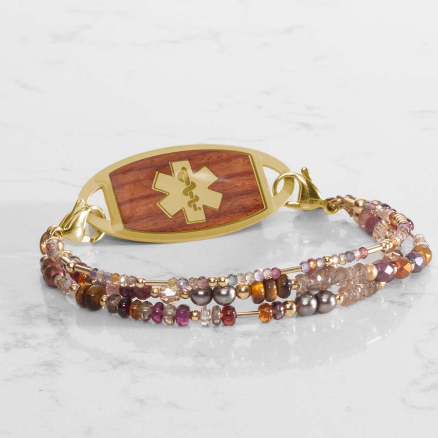 Fawn Medi ID bracelet paired with gold and cedar inlaid med ID tag on white marble countertop.