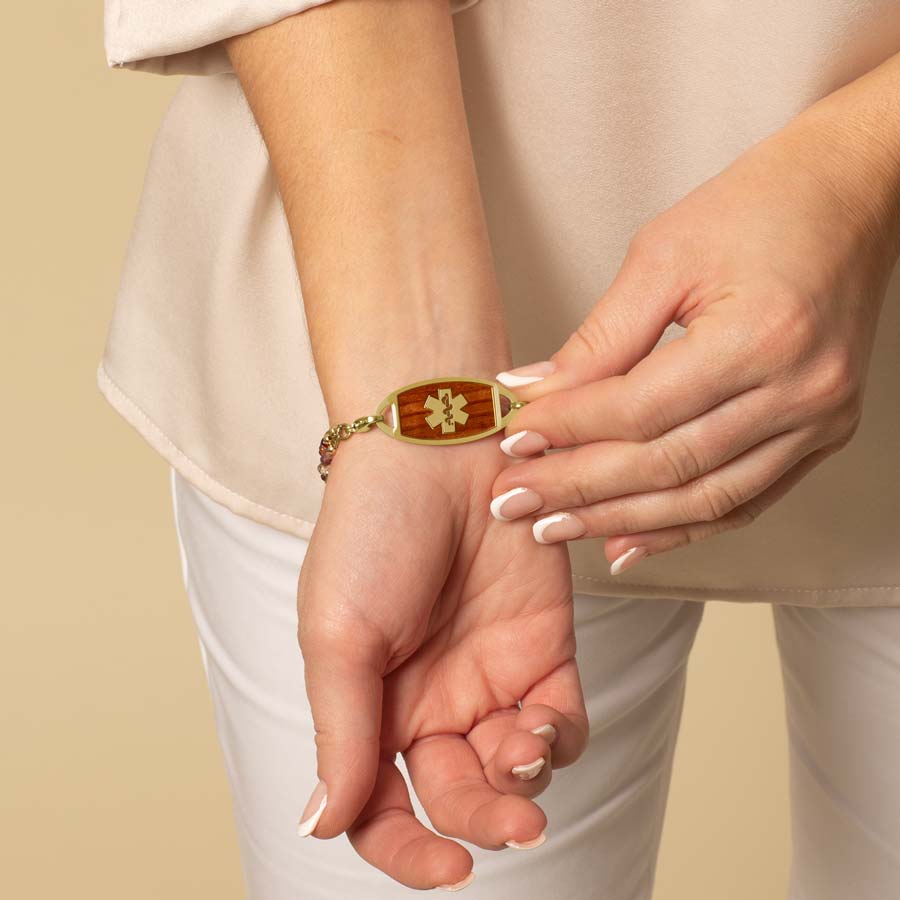 Woman displaying her Gold and Cedar Medical ID Tag