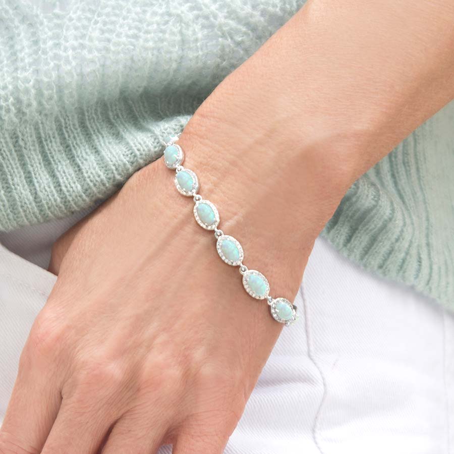 Woman wearing the Opal Medical ID Bracelet in Sterling Silver with natural oval-shaped opals and cubic zirconia accents