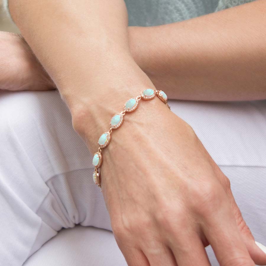 Woman wearing the Opal Medical ID Bracelet in Sterling Silver with natural oval-shaped opals and cubic zirconia accents