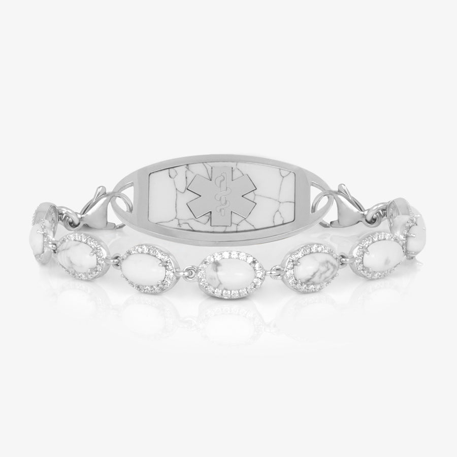 Bracelet with repeating links of simulated howlite and cubic zirconia crystals. Shown with a silver tone tag with howlite marble-like inlay