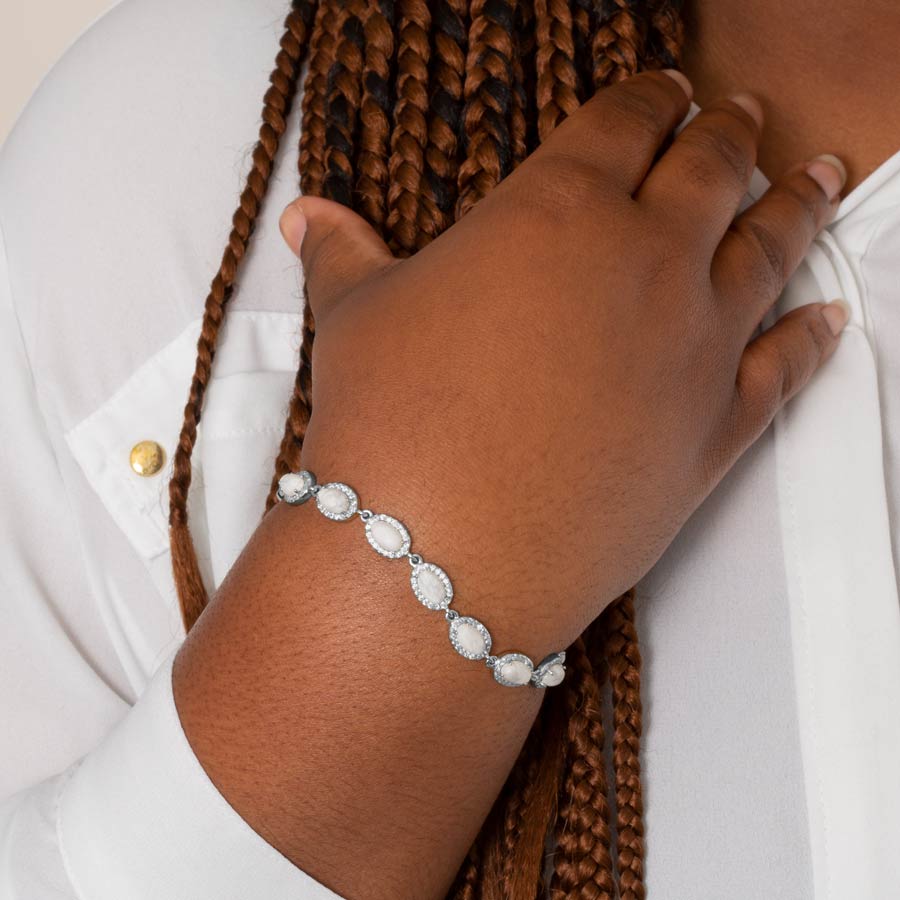 Woman wearing sterling silver medical ID bracelet with natural oval-shaped howlite and cubic zirconia accents