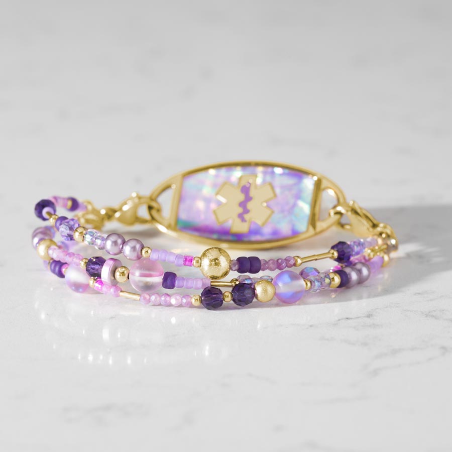 Jolie Beaded Med ID Bracelet paired with Gold and Lilac Abalone Med ID Tag on white marble countertop