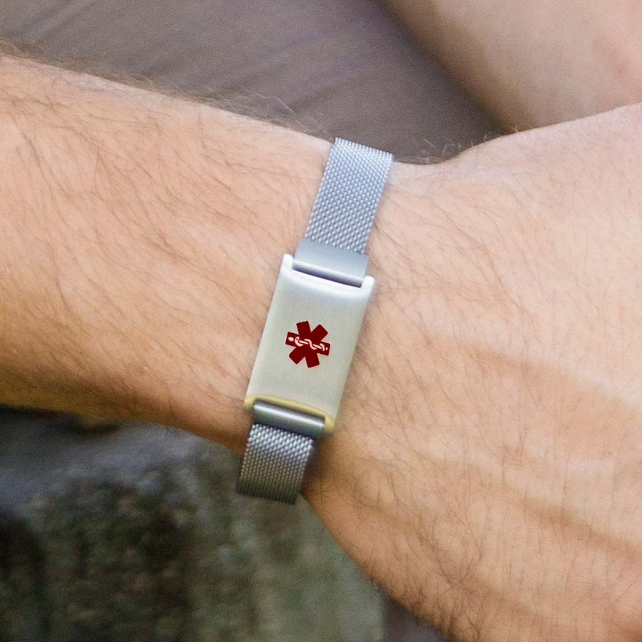 Man wearing stainless steel medical ID bracelet with red medical caduceus