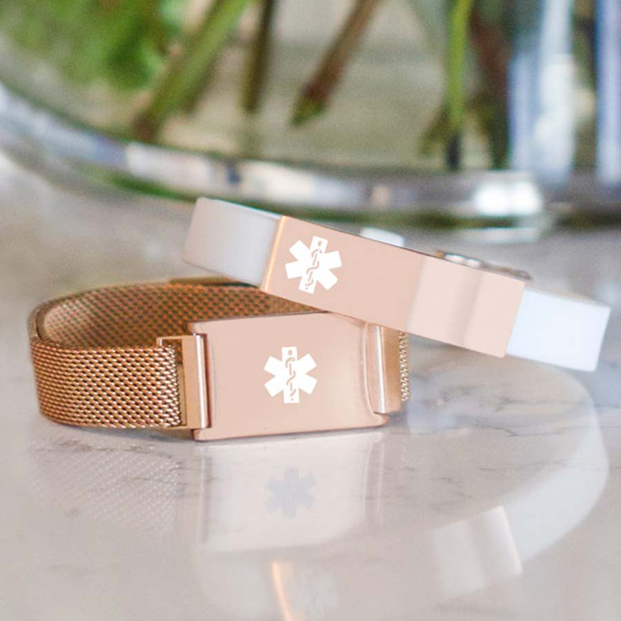 White and rose gold silicone medical ID bracelet stacked on top of rose gold medical alert with mesh band