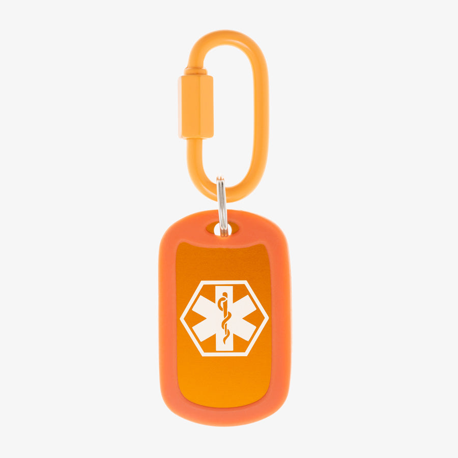 Carrot aluminum bag tag with white medical symbol and coordinating silicone silencer on matching carabiner clip.